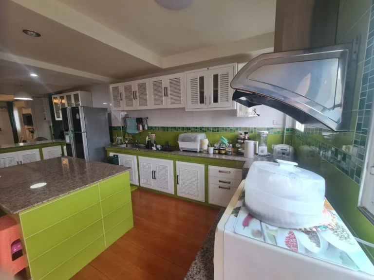 Large kitchen with a granite-topped island and white louvred cabinets
