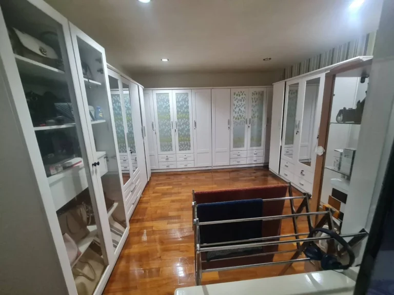 Walk-in closet with cabinets around the room and a wood floor