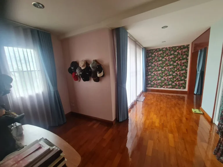 Wood-floored room with a floral wallpaper wall
