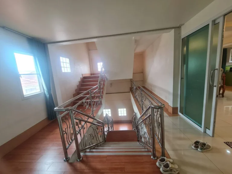 Stair hall with a floral stainless-steel railing
