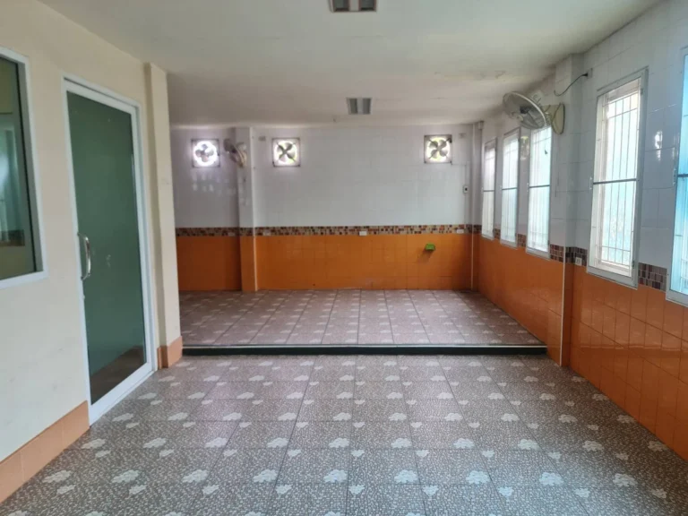 Open room with tiled walls, extractor fans and glass doors