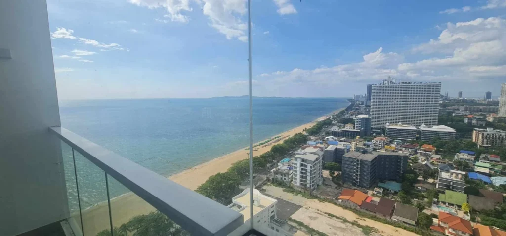 Balcony view from a high floor over the sea and the long curve of Jomtien Beach