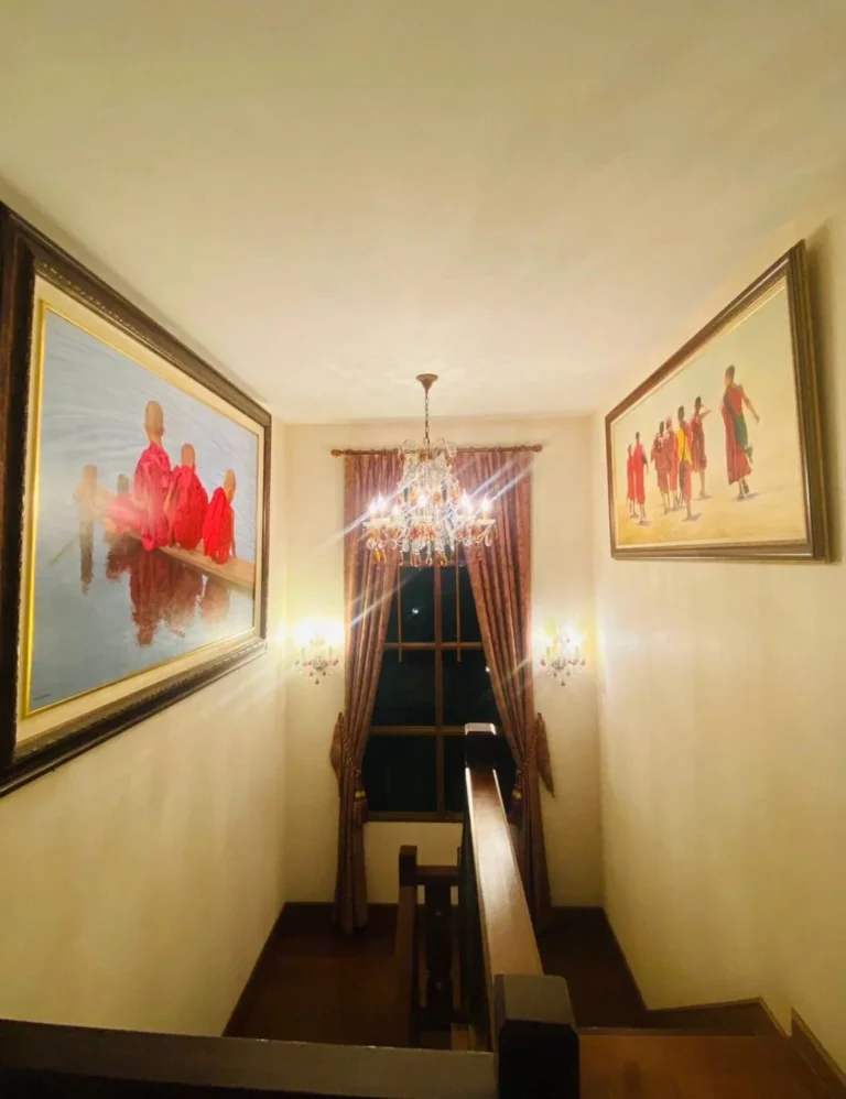 Staircase with a crystal chandelier and framed paintings