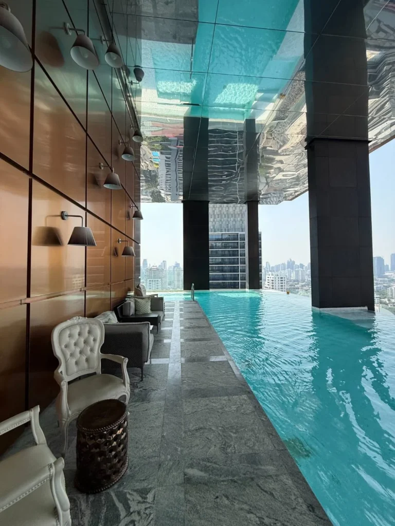 Infinity pool seen from the other end, with copper-toned wall panels and wall lamps