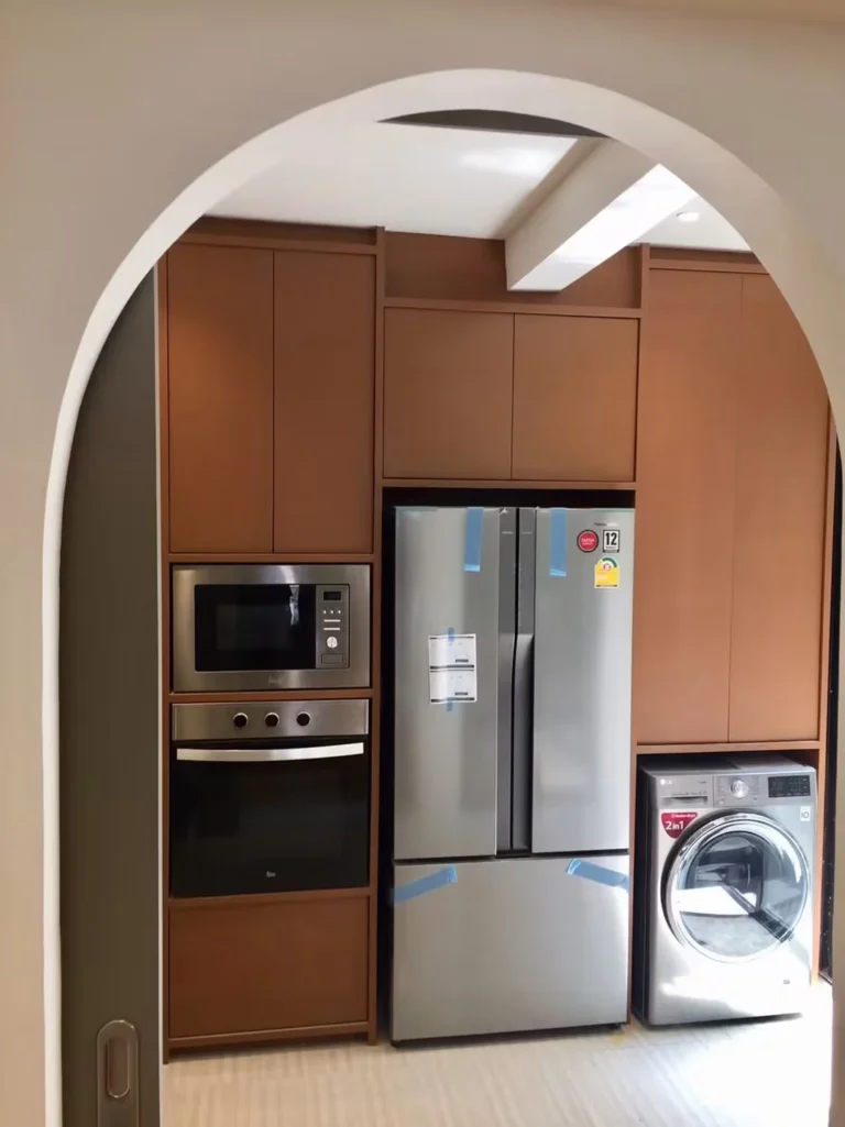 View through the arch into the kitchen: built-in oven and microwave, French-door fridge and LG washer-dryer