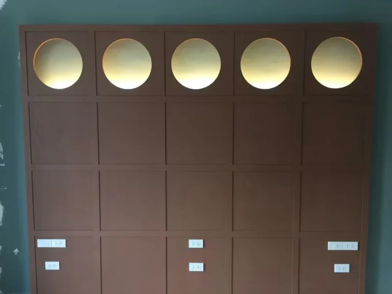 Wooden headboard wall with five lit circular niches
