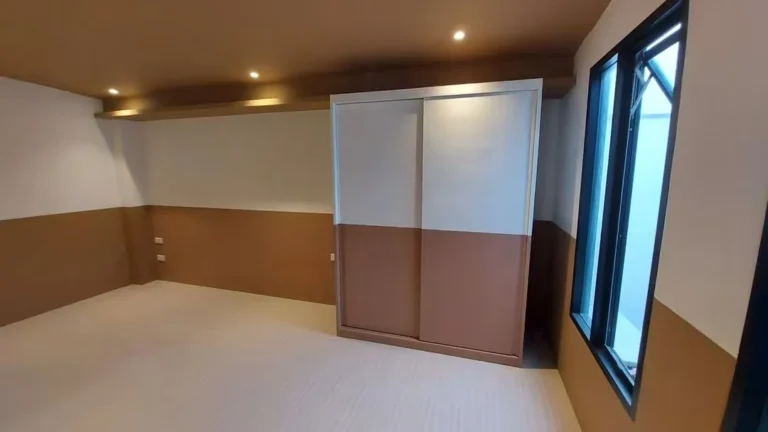 Bedroom with two-tone walls, a wood-tone ceiling with concealed lighting and a sliding-door wardrobe
