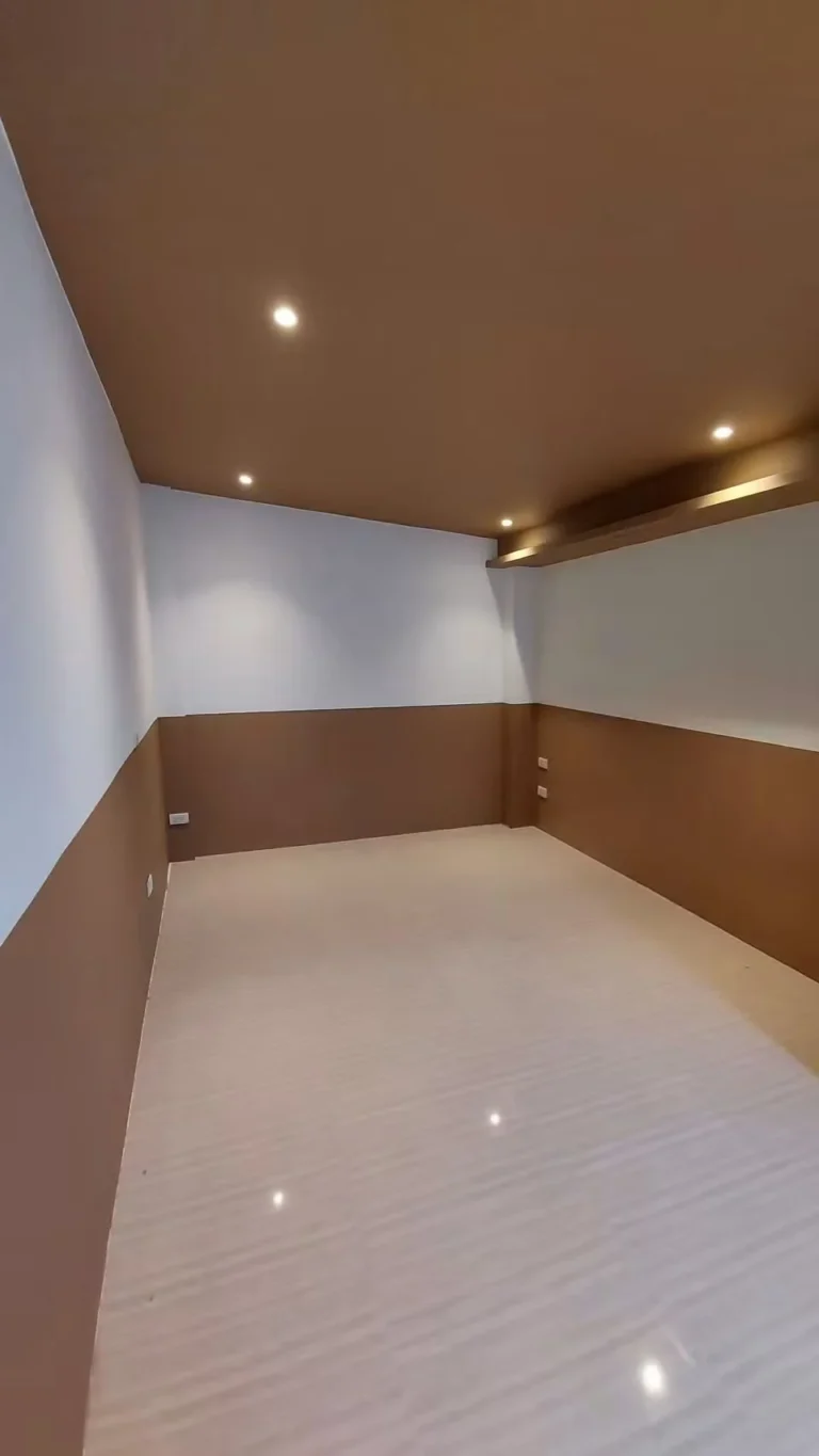 Bedroom with two-tone walls and a wood-tone ceiling with concealed lighting