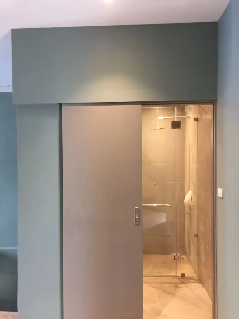 Sliding door to the bathroom in a green wall