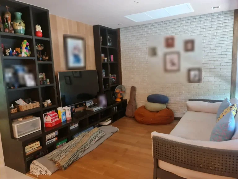 Family room with a wooden floor, a TV wall and shelves