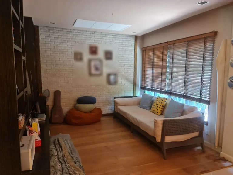 Family room with a wooden floor and a white brick wall