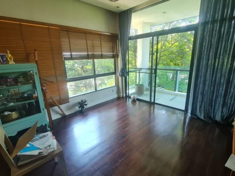 Upstairs bedroom opening onto a balcony with views of the trees