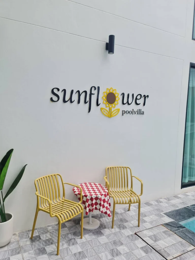 Sunflower poolvilla sign and poolside seating