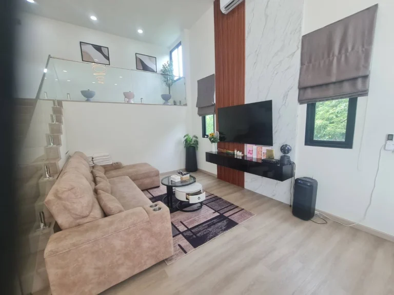Living room with L-shaped sofa and marble TV wall